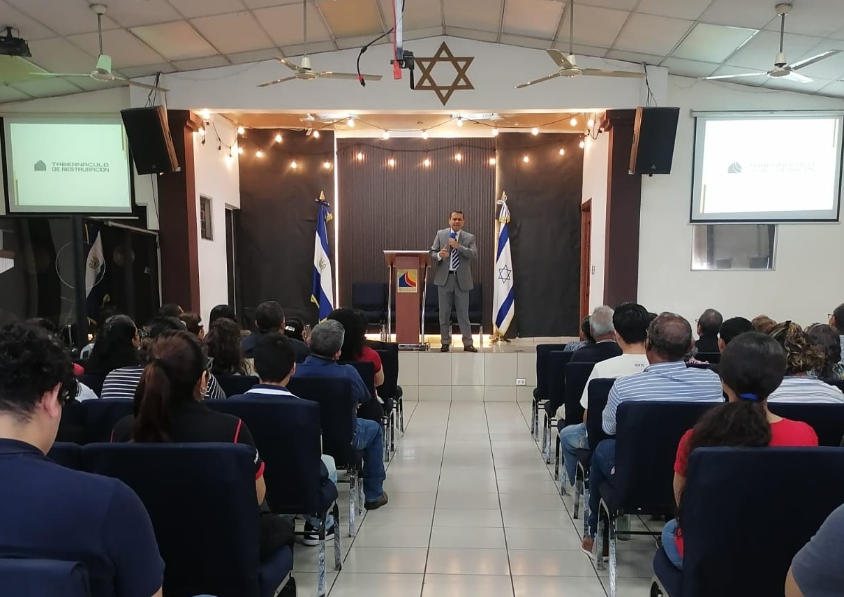 Pastor Rigoberto Campos orando por la congregación
